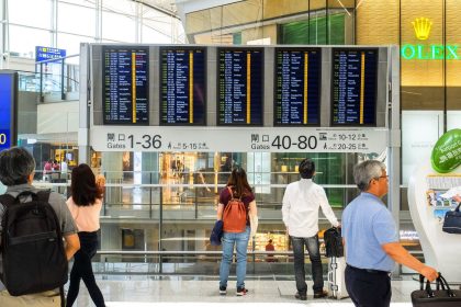 Passageiros consultam o painel de partidas no terminal de um aeroporto.