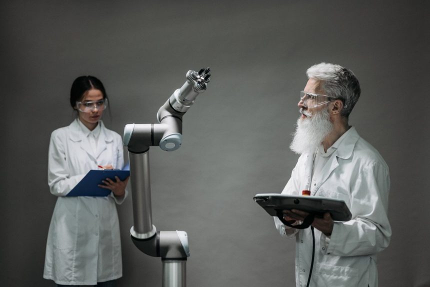 Dois cientistas trabalham com um braço robótico em um laboratório de pesquisa e inovação tecnológica.