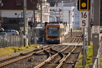 Tram circulando por uma linha urbana, em contexto de planejamento da cidade e proteção climática